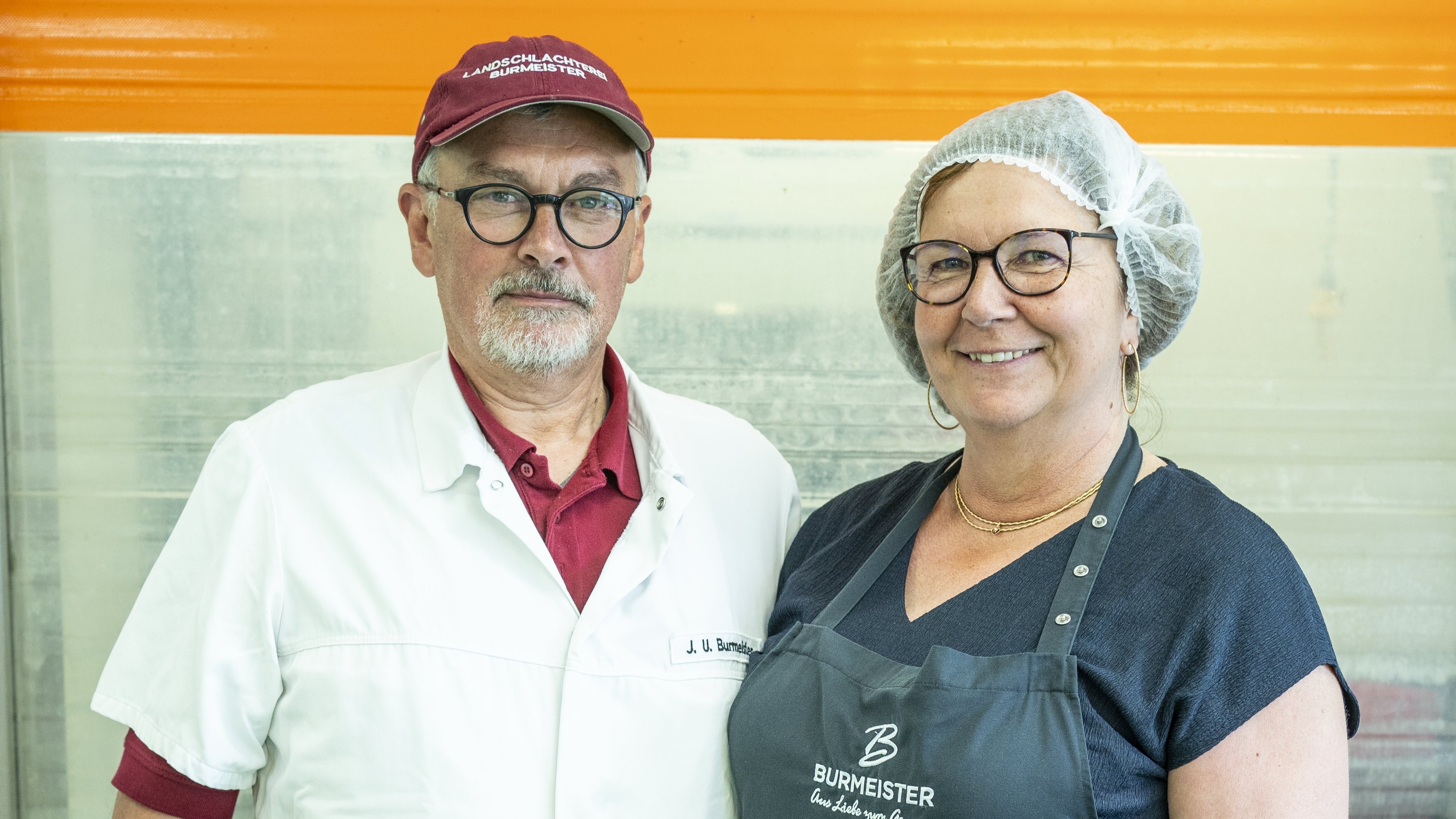 Mann und Frau in Weißkleidung schauen in die Kamera